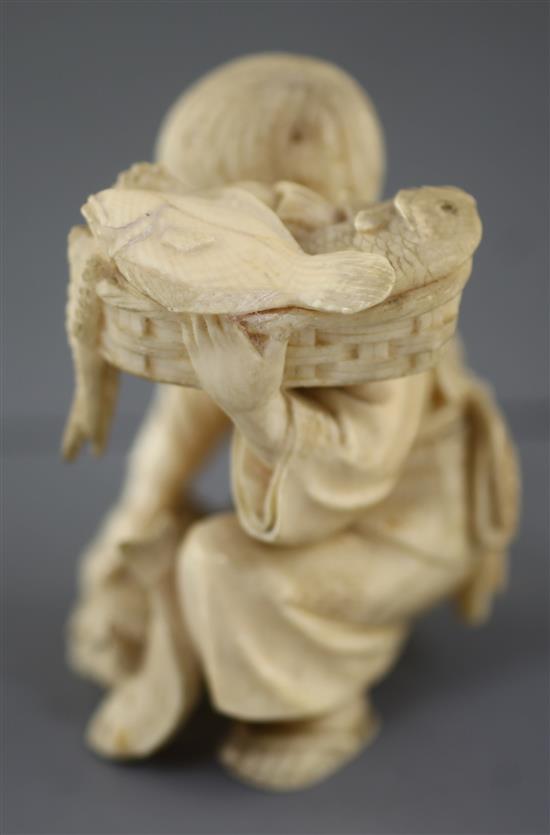 A Japanese ivory okimono of a boy with a dog, Meiji period, height 7.5cm excl. wood stand